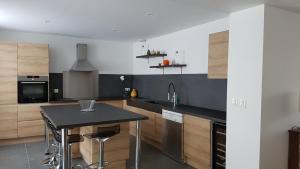 a kitchen with a table and a black counter top at Clos 1753 in Écueil