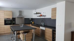 a kitchen with a table and a black counter top at Maison Marcel in Écueil