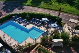 widok na basen z leżakami i parasolami w obiekcie Hotel Boomerang w mieście Tabiano Terme