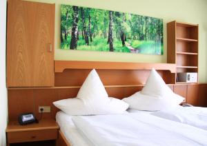 Ein Bett oder Betten in einem Zimmer der Unterkunft Hotel Garni Vier Jahreszeiten