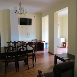 a dining room and living room with a table and chairs at Tvishi Guest House in Tsʼageri