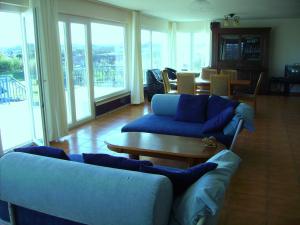 a living room with blue couches and a table at Villa Ortiga in Mação