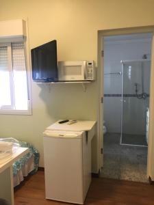 Uma TV ou centro de entretenimento em Vila Stellino Suítes