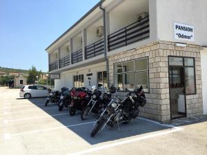 uma fila de motociclos estacionados fora de um edifício em Rooms & Pansion Odmor em Rovanjska