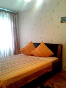 モスクワにあるApartamienty Dubininskaiaのベッドルーム1室(オレンジ色の枕が付いたベッド1台付)