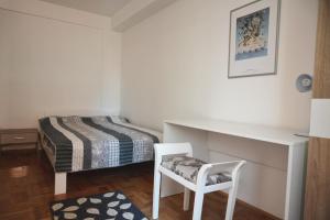 a bedroom with a bed and a desk and a chair at Trident Apartments in Niš