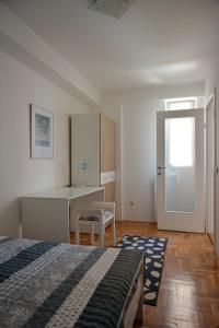 a bedroom with a bed and a desk and a table at Trident Apartments in Niš