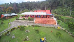 una casa su una collina con un ampio cortile di Finca Cafetera Las Mercedes a Cumaca