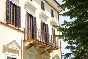 een gebouw met bruine luiken en een balkon bij Raffaello Residence in Sassoferrato
