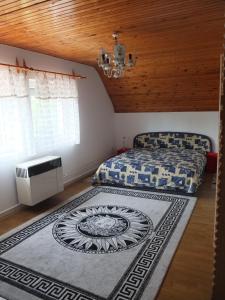 a bedroom with a bed and a rug on the floor at Osho Vendégház in Tiszafüred