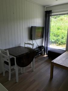 a living room with a table and a tv at Hybeltunet in Meråker