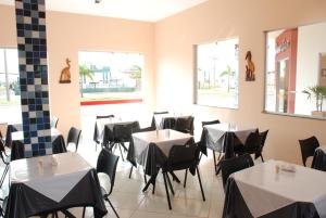 a restaurant with tables and chairs in a room at Hotel Veredas in Três Lagoas