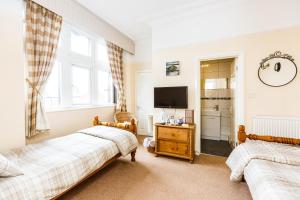 a bedroom with two beds and a tv in it at The Old Crown Inn in Sheffield