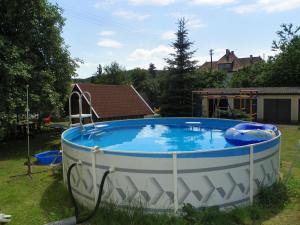 a large circular pool in a yard with a house at Landhotel Steigerwaldhaus in Burghaslach