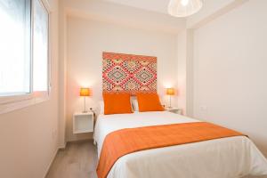 マラガにあるThyssen Museumの白いベッドルーム(大型ベッド1台、オレンジ色の枕付)