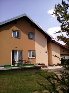 a house with a table and chairs in front of it at Rooms Marina in Korenica