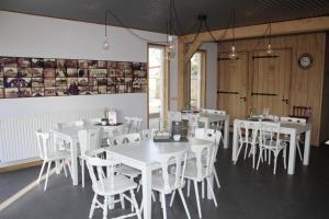 a dining room with white tables and white chairs at Hof van donzel in Nistelrode
