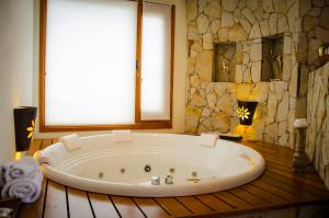 
a white bath tub sitting next to a window at Kkala Boutique Hotel in Salta
