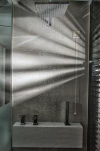 uma casa de banho com um lavatório e um espelho em Athens Lodge by Athens Prime Hotels em Atenas
