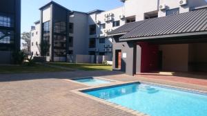 a swimming pool in front of a building at Lifestyle Apartments in Gaborone