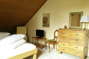 Schlafzimmer mit einem Bett, einer Kommode und einem Spiegel in der Unterkunft Strandhaus-Susi in Cuxhaven