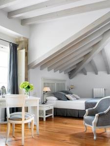 Un dormitorio con una cama y una mesa y sillas. en Posada Villa Esperanza, en Liérganes