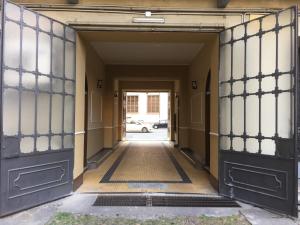 een toegang tot een gebouw met zwarte deuren bij Monolocale nizza 27 in Turijn
