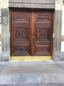 een grote houten deur aan de zijkant van een gebouw bij Monolocale nizza 27 in Turijn