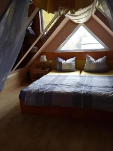 uma cama num quarto com uma grande janela em Ferienhaus- Dallgow em Dallgow