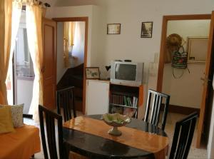 a dining room with a table and a television at Sotto L'Arco in Santo Stefano di Camastra