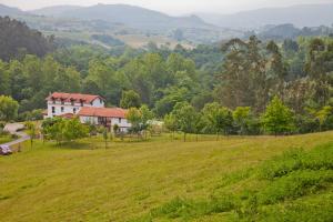 a house on a hill with a green field at Posada La Charola in Lamadrid