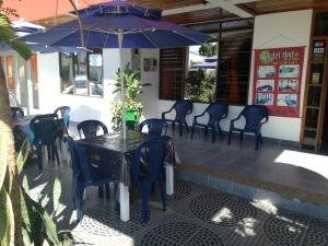 a table with chairs and an umbrella on a patio at Hotel Huito in Leticia