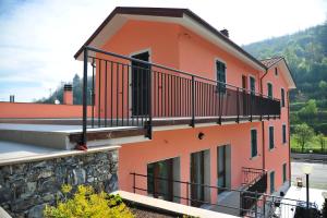 an orange building with a balcony on it at Affittacamere B&B Trattoria della Posta in Maissana