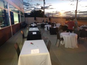 a restaurant with tables and chairs with the sunset in the background at Hotel Serra do Rio in Ibotirama