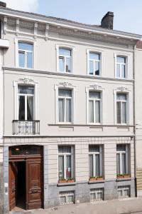 a white building with a brown door and windows at Atlas B&B in Ghent