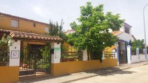 uma casa amarela e branca com uma cerca em Valdexpacio em Valdecaballeros