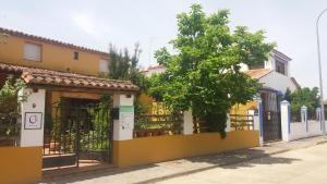 a yellow and white house with a fence at Valdexpacio in Valdecaballeros