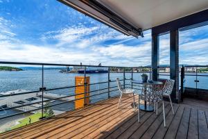 a balcony with a table and chairs and a view of the water at Wright Apartments - Sørenga in Oslo