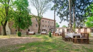 un patio con mesas y sillas frente a un edificio en Hotel Casa a Colori Venezia, en Dolo