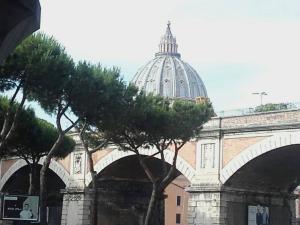 ローマにあるInterno 9 a San Pietroの背景の木々のドームを持つ建物