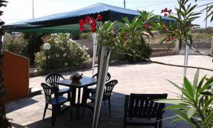 a table and chairs with flowers on a patio at Holiday House in Taviano