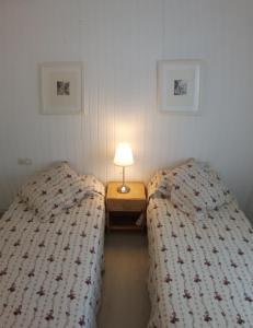 two beds in a room with a table with a lamp at apartament Sant Pere in Sant Pere Pescador