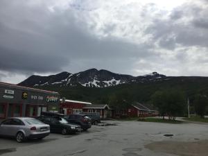 a parking lot with cars parked in front of a mountain at Tysfjord Hotel in Storjord I Tysfjord