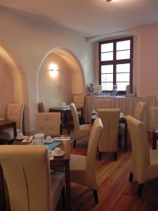 a dining room with tables and chairs and a window at Hotel Schwibbogen Görlitz in Görlitz