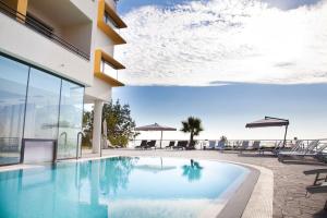 a swimming pool in front of a building at Esperia Palace Hotel & Resort Spa in Zafferana Etnea