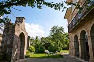 an old building with a table and chairs in a courtyard at Posada Villa Esperanza in Liérganes