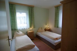 niewielka sypialnia z 2 łóżkami i 2 oknami w obiekcie Chalet Tirolerland w Mayrhofen