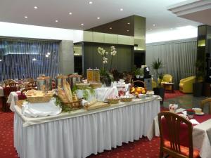 a buffet table with food on it in a lobby at Hôtel d’Angleterre Grenoble Hyper-Centre in Grenoble