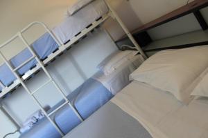 Letto a castello con lenzuola e cuscini bianchi di Park Hotel a Castrocaro Terme