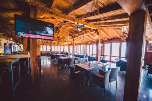 a restaurant with tables and chairs and a flat screen tv at Apartments Horizont in Budva